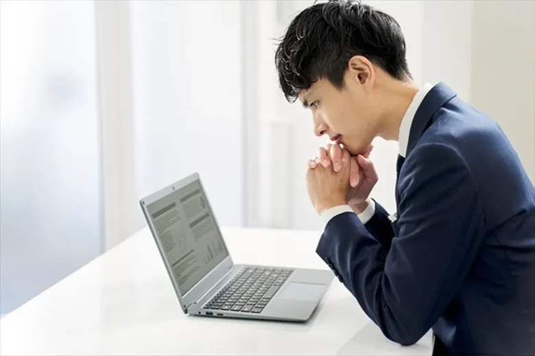 ノートPCを見て考え込むビジネスパーソン