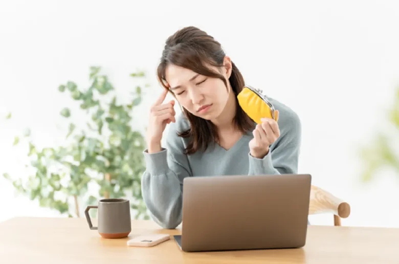 財布を手に頭を悩ませる女性