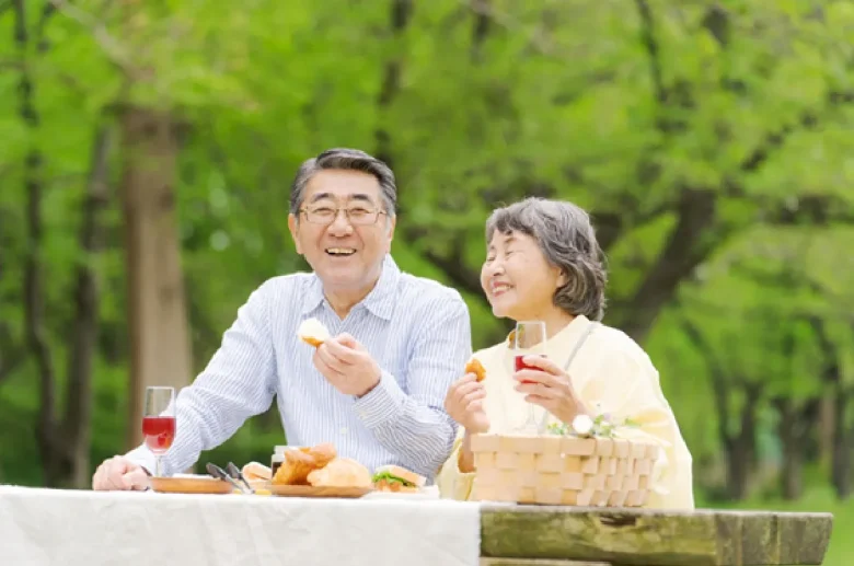 老夫婦が外で食事を楽しむ姿