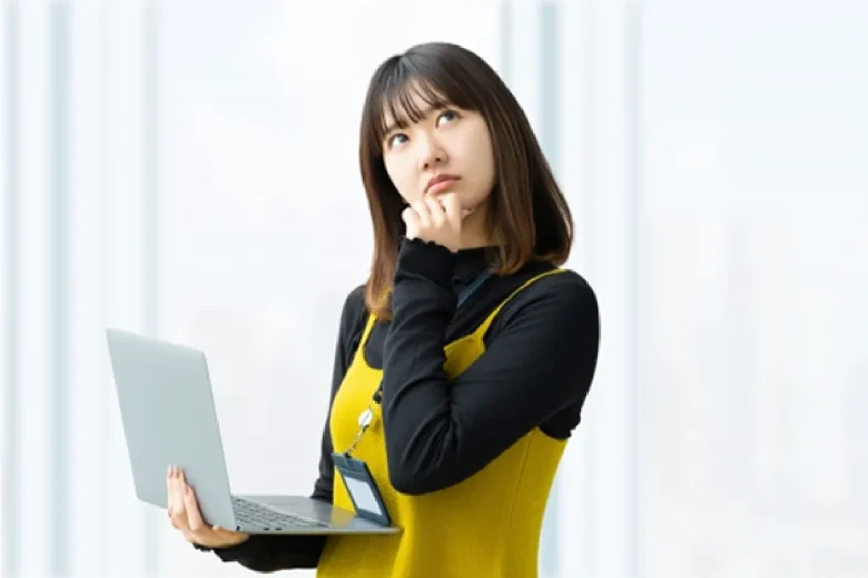 タブレットを片手に首をかしげて考える女性