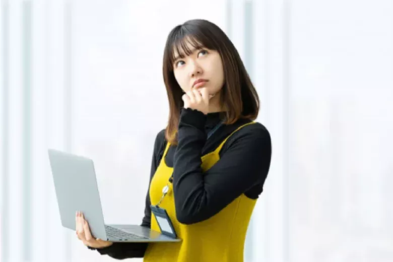 タブレットを片手に首をかしげて考える女性